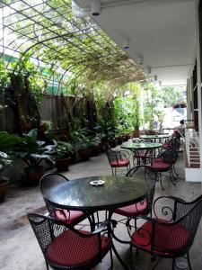 a patio with tables and chairs and potted plants at Pension Natividad in Manila