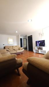 a living room with couches and a flat screen tv at Rincón del Descanso in Loja