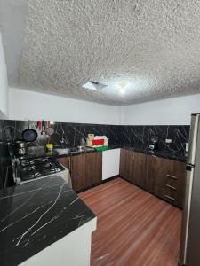 a kitchen with black and white counter tops at Rincón del Descanso in Loja +9 photos