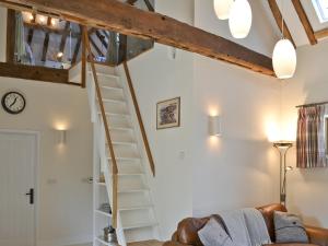 a spiral staircase in a living room with a couch at Fig Cottage in Brabourne