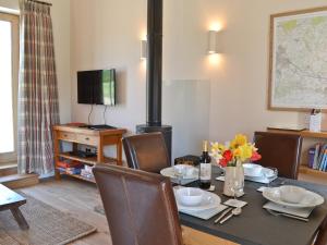 a dining room with a table and a fireplace at Fig Cottage in Brabourne