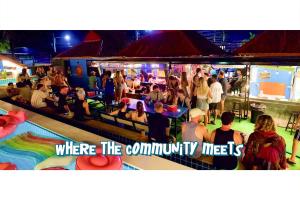 Eine Menschenmenge steht bei einer Party um einen Pool herum. in der Unterkunft Kohmunity Hostel in Thongsala