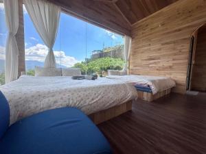 two beds in a room with a large window at Mando Homestay in Bắc Yên