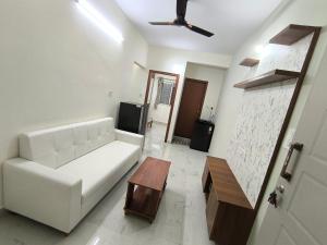 a living room with a white couch and a table at BroFlats in Bangalore