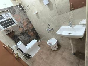 a bathroom with a toilet and a sink at BroFlats in Bangalore