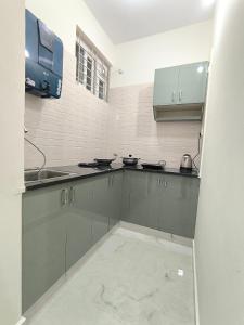 a kitchen with gray cabinets and a sink at BroFlats in Bangalore +1 photo
