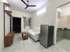 a living room with a ceiling fan and a refrigerator at BroFlats in Bangalore