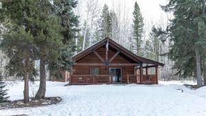 a log cabin in the woods in the snow at Legacy Vacation Rental in Valemount