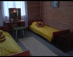a room with two beds and a desk and a chair at Keltainen talo in Ylivieska