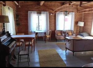 a living room with a piano and a table and chairs at Keltainen talo in Ylivieska