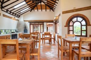 a dining room with wooden tables and chairs at Hacienda Cascanueces in Villa de Leyva