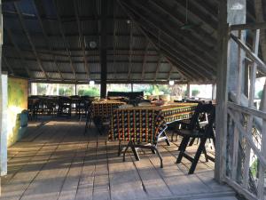 a patio with tables and chairs on a porch at Campement les Baobabs Abene in Abémé