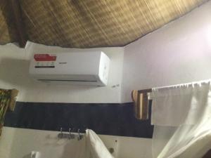 a bathroom with a air conditioner on the wall at Campement les Baobabs Abene in Abémé +63 photos