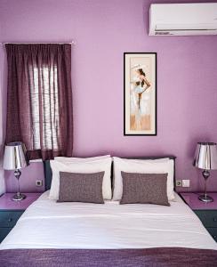 a purple bedroom with a white bed with two lamps at Olive Nest, Cozy Apartment in Ammoudara in Ayía Marína