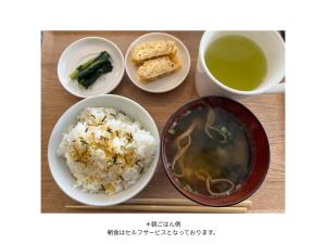 a table with bowls of rice and a cup of tea at Togari Sunshine Lodge in Iiyama