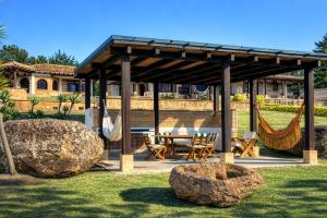 a pavilion with a table and hammocks in a yard at Hacienda Cascanueces in Villa de Leyva