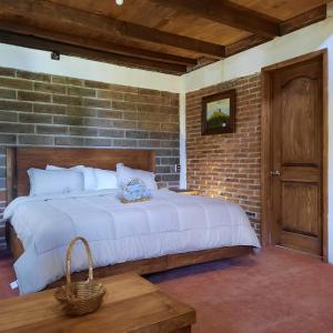 a bedroom with a large bed with a brick wall at Altépetl Cabañas Zacatlán in Tomatlán