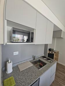 a kitchen with white cabinets and a sink at Tower Suites - Exclusiva Suite 9 - Centro de Neuquén in Neuquén