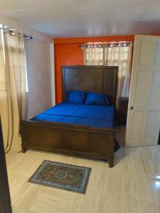 a bedroom with a large wooden bed with blue sheets at Optimum Apartments in Providence