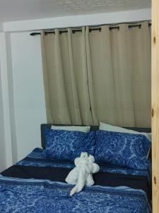 a white stuffed animal laying on a bed at Optimum Apartments in Providence +1 photo