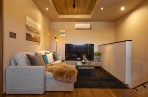 a living room with a couch and a flat screen tv at Resoreat Takashima in Imazu