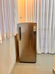 a metallic refrigerator sitting in front of a window at Global Residency in Kanjirapalli