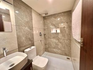 a bathroom with a white toilet and a sink at Global Residency in Kanjirapalli +17 photos