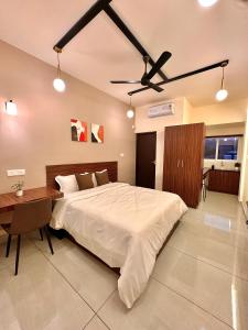 a bedroom with a bed and a desk and a ceiling fan at Global Residency in Kanjirapalli