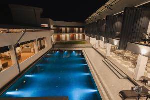 a large swimming pool with blue water in a building at COUNTRYSIDE RESORT MURTi in Chālsa Mahābāri