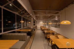 a row of tables and chairs in a restaurant at COUNTRYSIDE RESORT MURTi in Chālsa Mahābāri