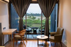 a room with a balcony with chairs and a table at COUNTRYSIDE RESORT MURTi in Chālsa Mahābāri