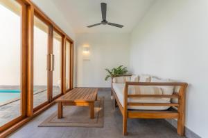 a room with a bed and a table and a bench at Kixi Beach in Unawatuna