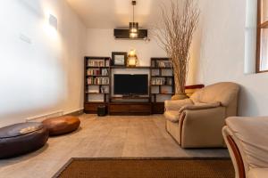 a living room with a couch and a television at Kixi Beach in Unawatuna