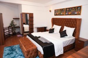 a bedroom with a large bed with a brown tufted headboard at Restora Ella in Ella