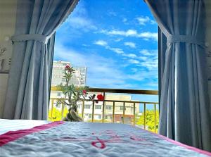 a bedroom with a window with a view of a city at KHÁCH SẠN HƯNG THỊNH - Gần biển, gần cảng khách - Trung tâm Lý Sơn in Ly Son