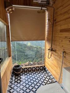 a bathroom with a window and a black and white tiled floor at Mando Homestay in Bắc Yên +107 photos