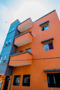 an orange building with balconies on the side of it at Résidence Aïcha in Rufisque