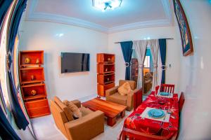 a living room with a table and a dining room at Résidence Aïcha in Rufisque +23 photos