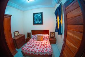 a small bedroom with a bed and a wooden door at Résidence Aïcha in Rufisque