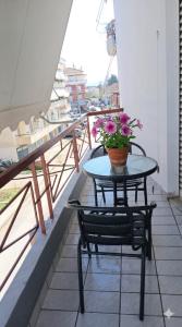 a table and chairs on a balcony with flowers on it at Welcome studio in Preveza