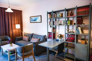 a living room with a table and chairs and a book shelf at Blue Petal Apartment, Relaxed Heraklion Stay in Amoudara Herakliou
