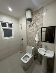 a bathroom with a toilet and a sink at The Huddle - Dusk in Dehradun +10 photos