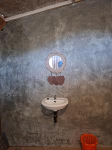 a bathroom with a sink and a mirror on the wall at Penempuran cottage in Masbagik
