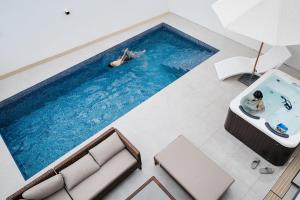 a person swimming in a pool with a bath tub at MIRATIO Umui Sauna&Spa in Onna