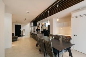 a dining room and kitchen with a table and chairs at MIRATIO Umui Sauna&Spa in Onna
