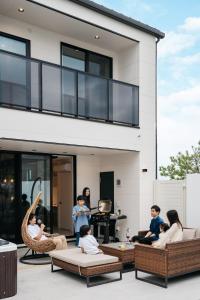 a group of people sitting on the patio of a house at MIRATIO Umui Sauna&Spa in Onna