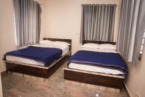 two beds sitting next to each other in a bedroom at Hotel Koyla Boarding and Lodging in Chikmagalūr