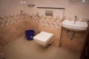 a bathroom with a toilet and a sink at Hotel Koyla Boarding and Lodging in Chikmagalūr +21 photos
