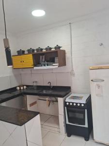 a small kitchen with a stove and a refrigerator at Casa blue in Aracati