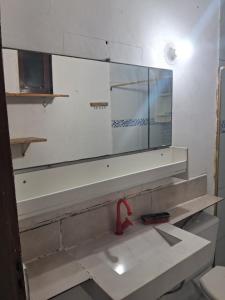a mirror above a sink in a bathroom at Casa blue in Aracati